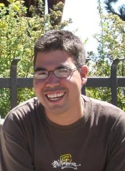 A man with glasses smiling for the camera.