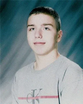 A young man with short hair is smiling.