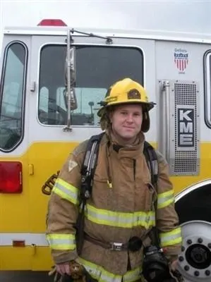 A fireman standing in front of a fire truck.