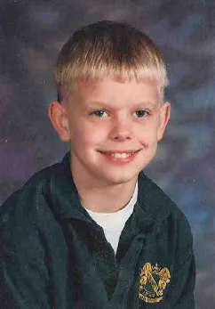 A young boy with blonde hair and a black shirt.