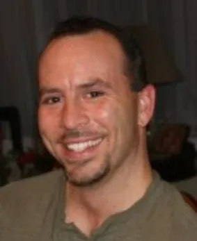 A man smiling for the camera with his teeth missing.