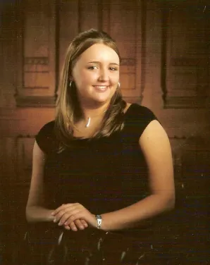 A woman in black shirt and white necklace.