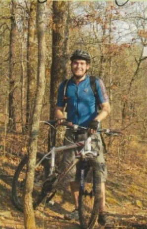 A man riding a bike through the woods.