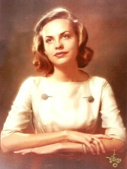 A woman in white dress with her hands crossed.