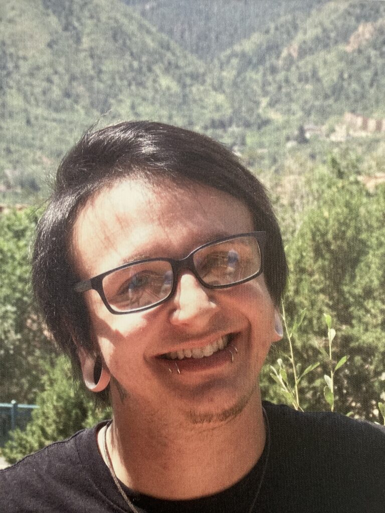 A person with glasses smiling for the camera.