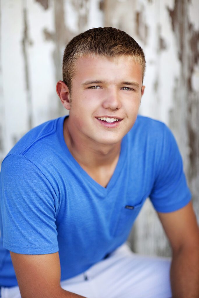 A young man in blue shirt posing for the camera.