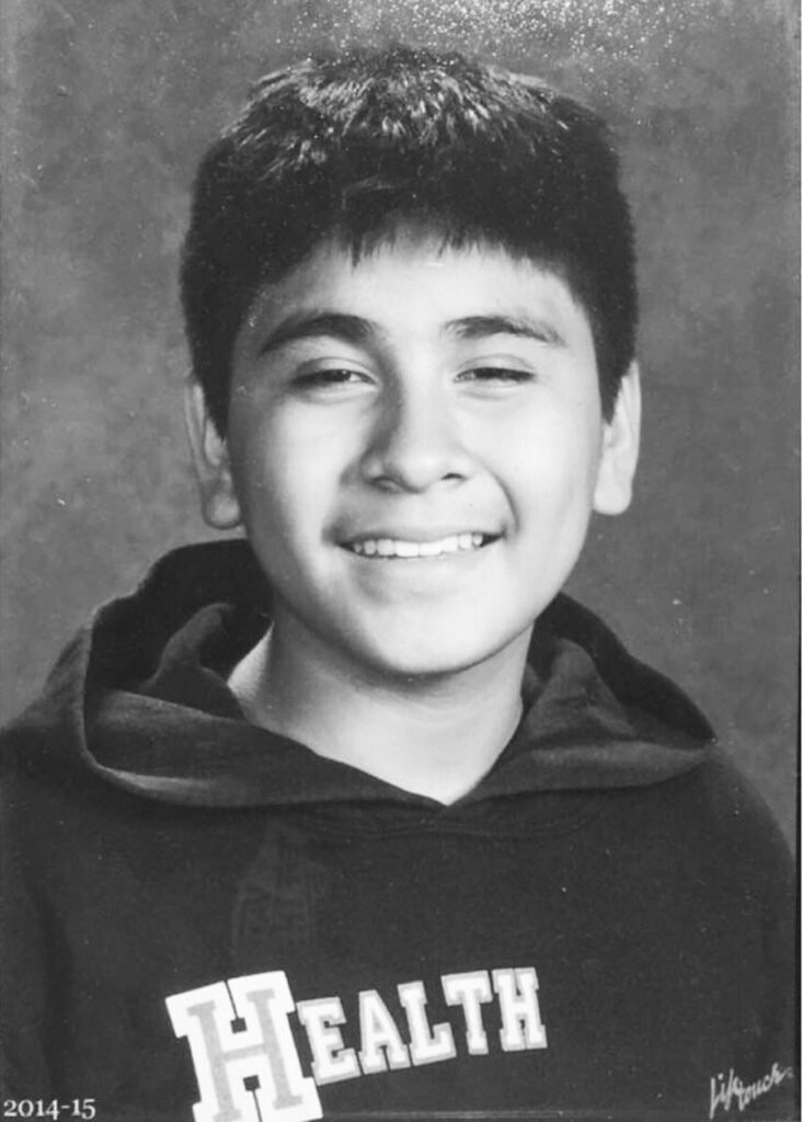 A young boy is smiling for the camera.