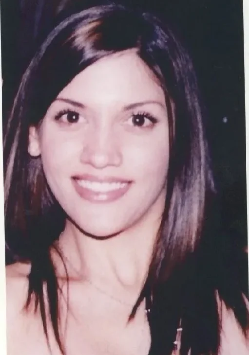 A woman with long hair and a smile.