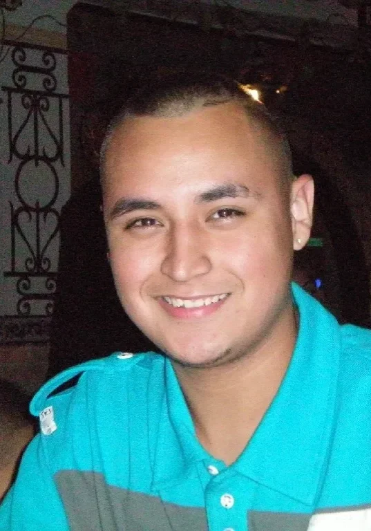Anthony Varela A man with a shaved head and blue shirt.