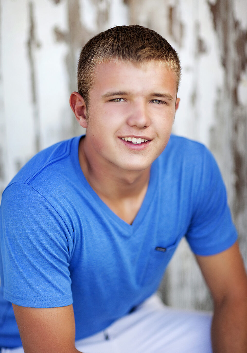 A young man in blue shirt posing for the camera.