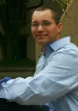 Sgt. Brandon Vance A man in blue shirt and glasses sitting on the ground.