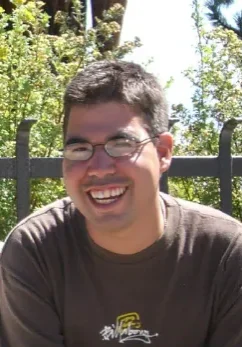 A man with glasses smiling for the camera.