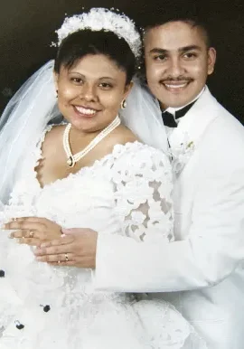 A man and woman in white wedding attire.