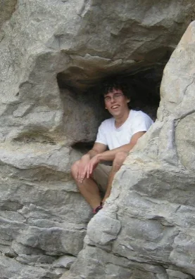 Daniel Jason Reiter A man sitting in the rocks of a cave.