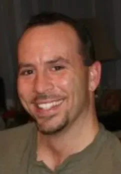 A man smiling for the camera with his teeth missing.