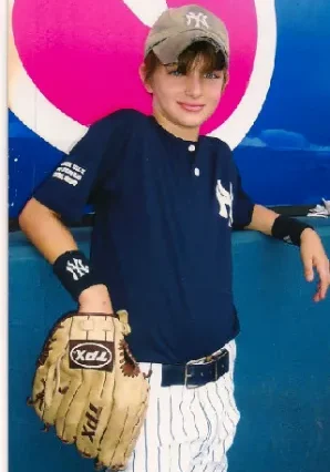 A young boy holding a baseball glove in his hand.