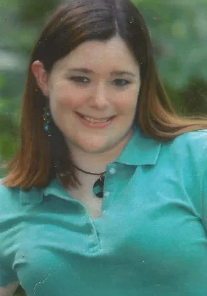 A woman in a blue shirt smiling for the camera.