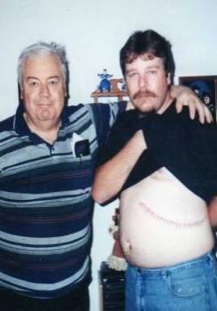 A man and an older gentleman posing for the camera.