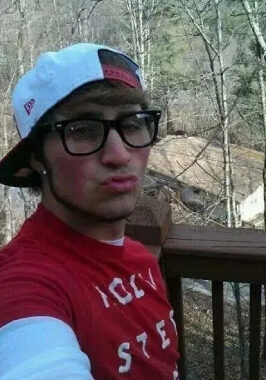 Organ Donor Hall Of Fame A man wearing glasses and a hat standing on top of a wooden deck.