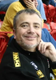 A man sitting in the stands of an arena.