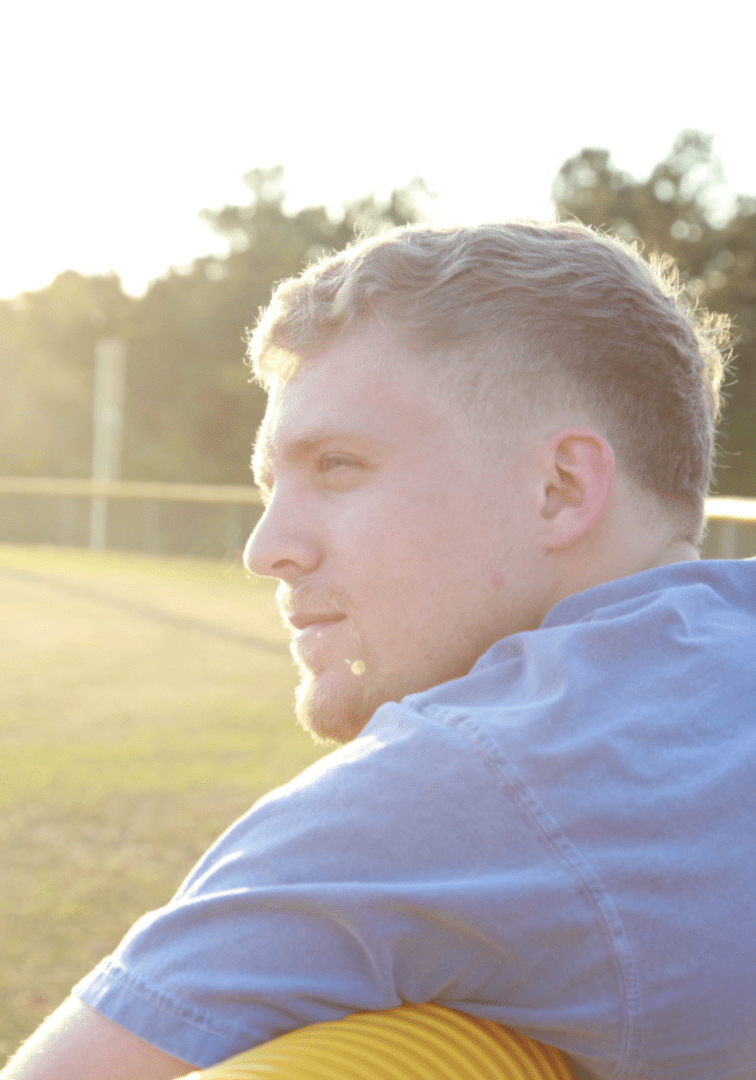 A man sitting on the ground with a ball in his hand.